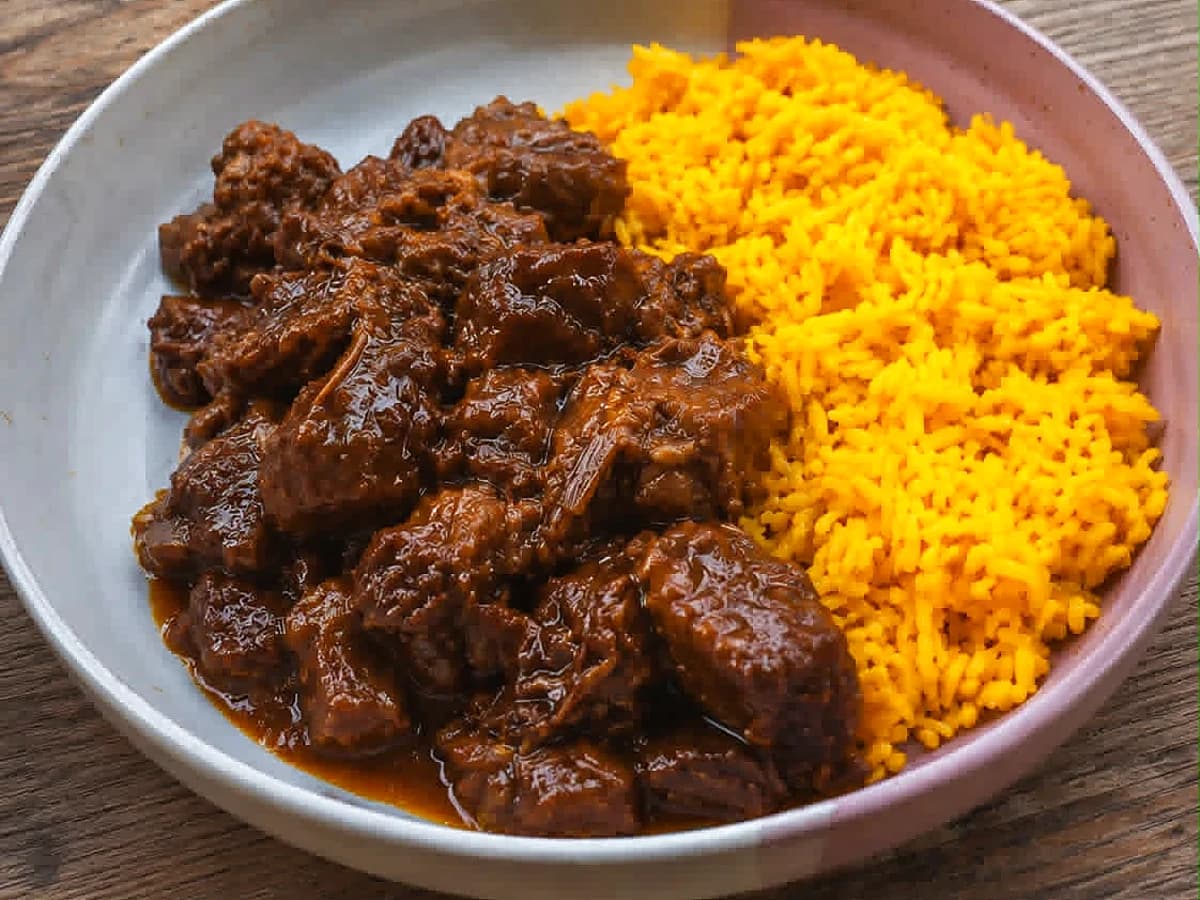 Daging Smoor van sukade met gele rijst op een bord